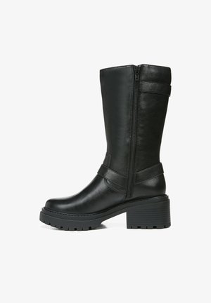 Schwarze Lederstiefel bis zum Knie mit einem seitlichen Reißverschluss, einem breiten Absatz und Gummisohle. Mit einem Riemen um den Knöchel für zusätzlichen Halt.