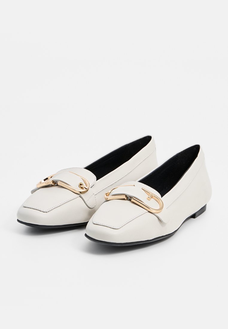 Weiße Lederschuhe mit quadratischer Zehenpartie, mit einem goldfarbenen Metallelement vorne und einer schwarzen Gummisohle. Glatte Textur, minimales Design.