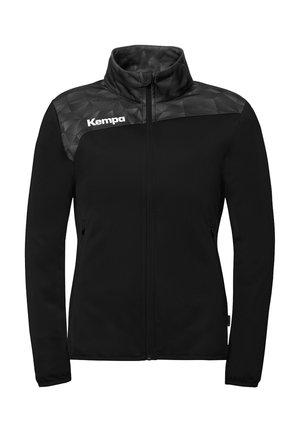 Schwarze Full-Zip-Jacke mit hohem Kragen, strukturiertem geometrischem Muster auf der oberen Brust und den Schultern sowie weißem Kempa-Logo auf der linken Brust.