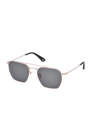 Lunettes de soleil aviateur noires à monture métallique avec verres teintés foncés et branches fines se terminant par des manchons noirs incurvés.