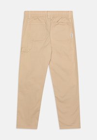 Béžové bavlněné kalhoty s elastickým pasem, dvěma zadními kapsami a postranní kapsou. Tkanina má hladkou texturu a pohodlný střih.