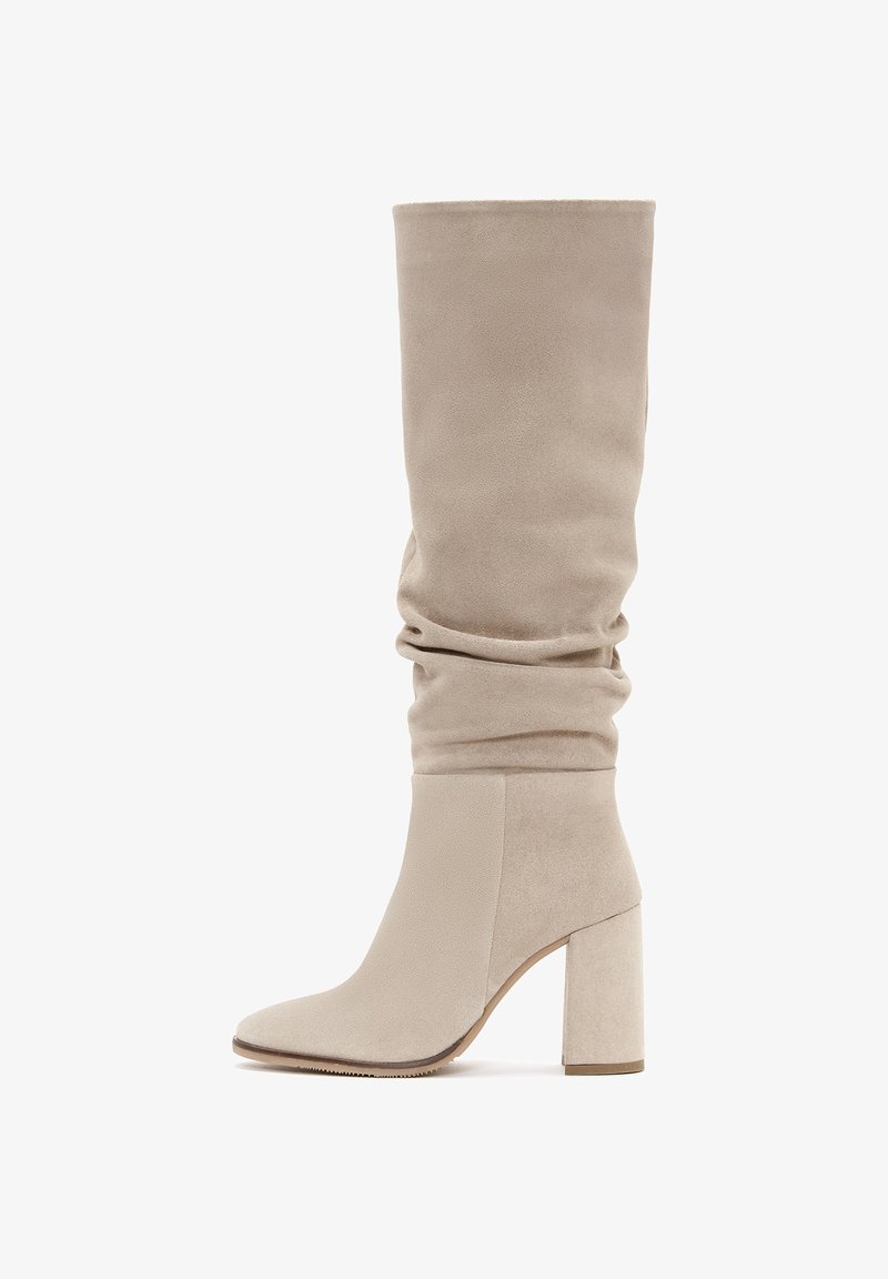 Bottes hautes en suédine beige avec une tige ample, dotées d'un bout carré et d'un talon bloc épais pour la stabilité et le confort.