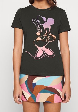 Kvinde iført sort t-shirt med pastel Minnie Mouse grafik og multifarvet abstrakt mønstret mininederdel.