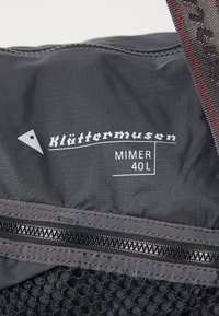 Schwarzer 40L Klättermusen Mimer Rucksack mit einer strukturierten Mesh-Tasche, einem horizontalen Reißverschluss und einem dreieckigen Logodetail. Strapazierfähiges Material.