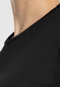 Schwarzes, tailliertes Shirt mit rundem Halsausschnitt und kurzen Ärmeln. Hergestellt aus glattem, dehnbarem Stoff mit einer weichen Textur.