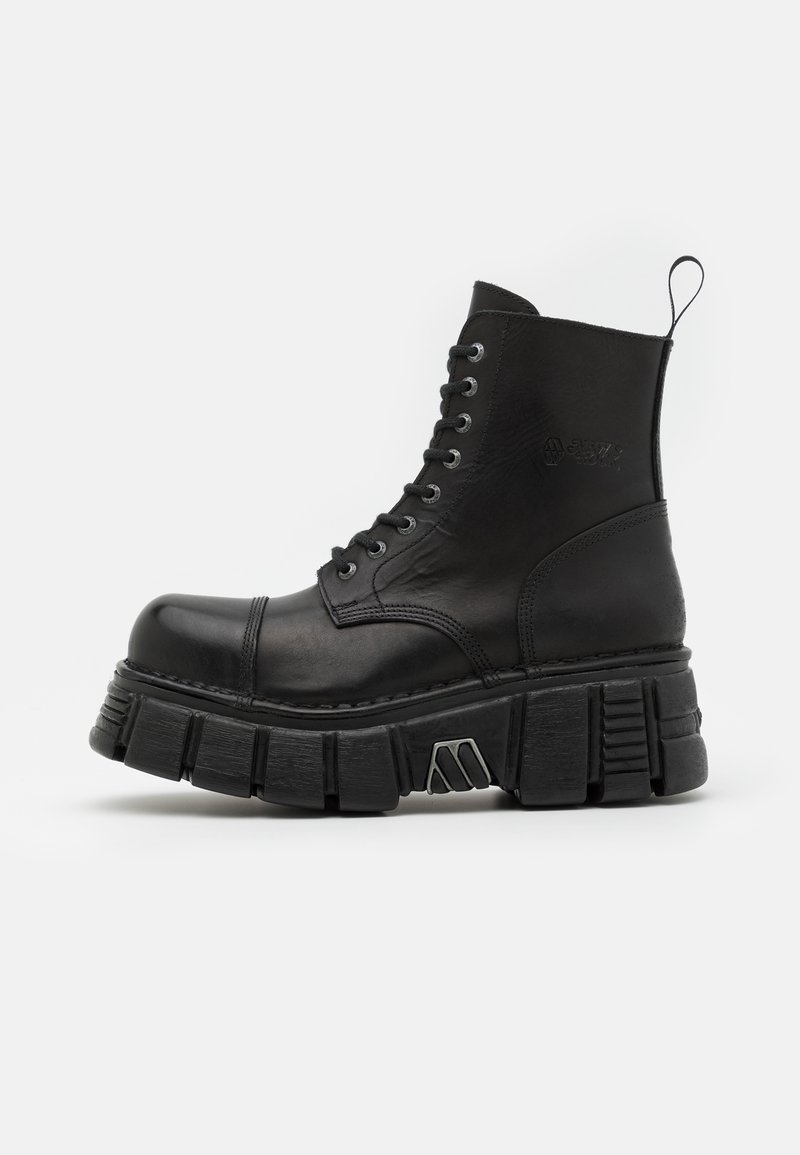 Bottines en cuir noir avec une semelle épaisse et chunky, présentant un design à lacets et une languette en boucle à l'arrière. Accents de surface texturée.