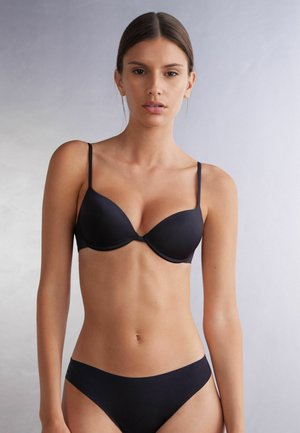Zwart lingerieset met een gladde, gepadde beha met dunne bandjes en bijpassende lage slips, gemaakt van een zachte, rekbare stof.