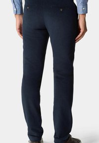 Ciemnoniebieskie kordowe spodnie o slim fit, z tylnymi kieszeniami i gładkim, teksturowanym wykończeniem. Podkreślone dwoma guzikami.