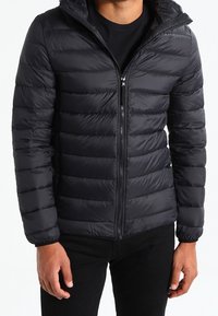 Schwarze Steppjacke mit Reißverschluss und Kapuze, mit gesteppte Abschnitte. Hergestellt aus leichtem, synthetischem Material mit langen Ärmeln.