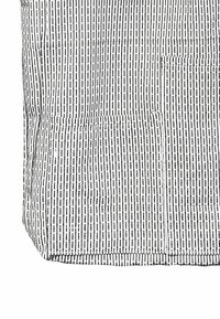 Svītrainas melnā un balt�ā audums ar vertikālām līnijām un raupju virsmu. Labajā pusē redzama kabata.