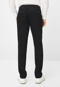 Schwarze Hose mit geradem Schnitt, aus einem glatten Stoff, mit zwei Gesäßtaschen und dezenten Nähten.
