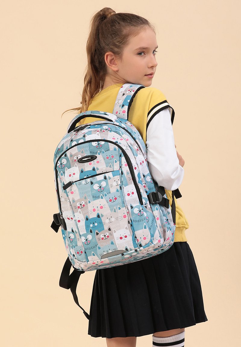 Sac à dos avec un motif de chat dans des couleurs pastel, avec des accents bleus, gris et blancs. Bretelles ajustables et une poche frontale. Texture lisse.