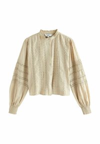 Blouse beige à boutons avec un col haut, tissu texturé, détails en dentelle et manches évasées. Présente des poignets élastiques et un design court.