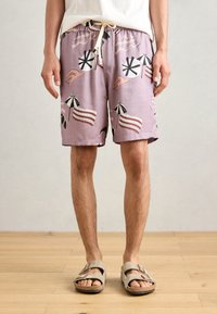 Shorts de bain lilas avec des imprimés sur le thème de la plage comme des parapluies et des vagues, dotés d'une taille élastique et d'un cordon de serrage.