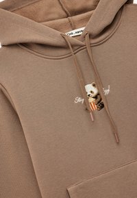 Sudadera con capucha marrón hecha de tela suave, con un bordado de un panda sosteniendo palomitas de maíz y un bolsillo canguro. Cordones a juego.