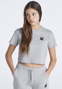Camiseta corta gris en una suave mezcla de algodón, con mangas cortas y un escote redondeado. Logotipo negro en el lado izquierdo del pecho.