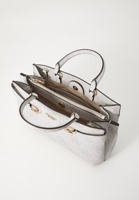 Borsa a mano bianca con una superficie testurizzata, esterno a fantasia, hardware dorato, due manici superiori e un compartimento interno con zip.