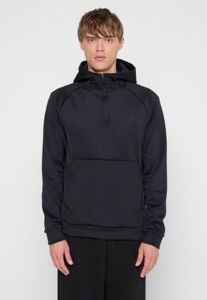 Czarny kapturowy sweatshirt z teksturowanej tkaniny. Posiada półzamknięcie i kieszeń kangurkę, cechując się minimalistycznym, eleganckim wyglądem.