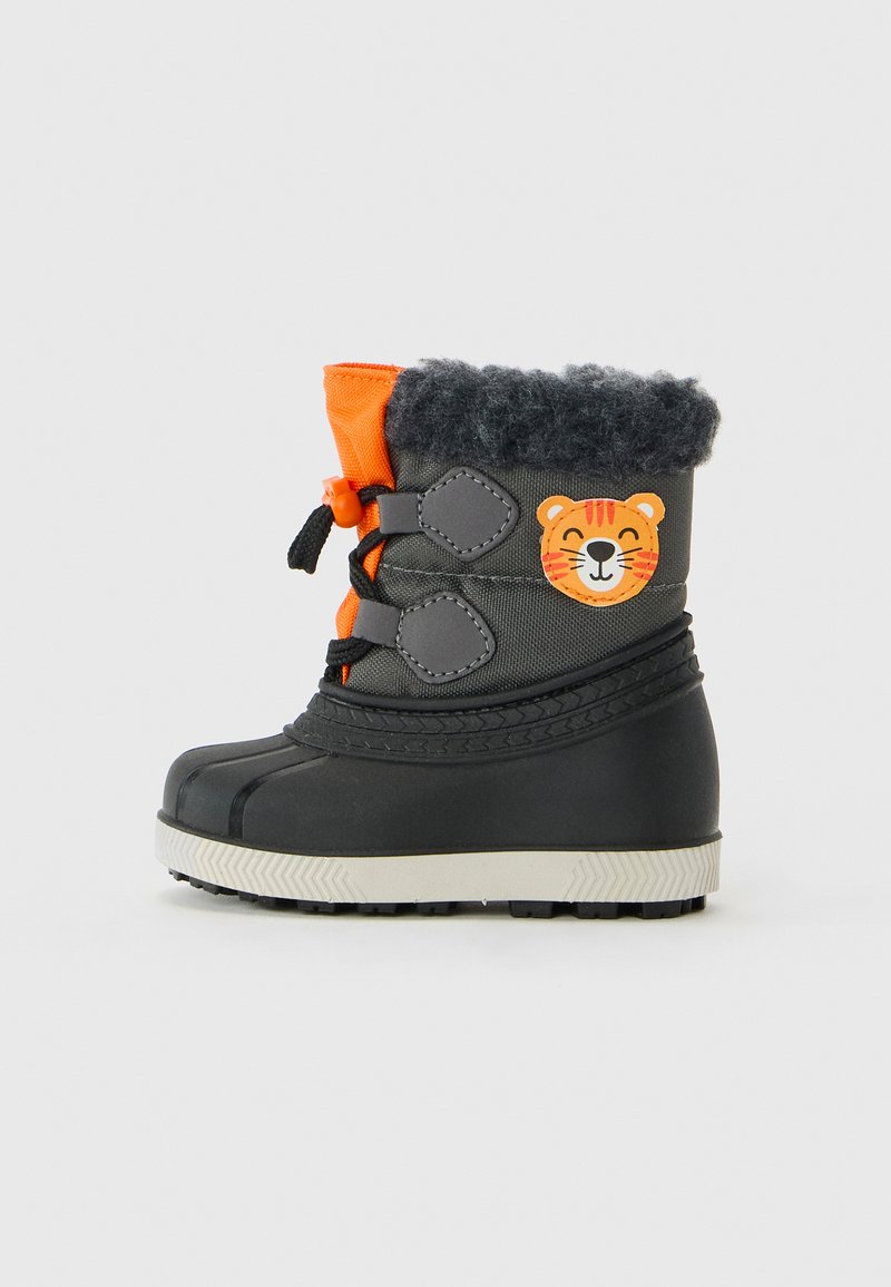 Barne vinterstøvler i svart og oransje med lodden kant, svarte snørebånd og et cheerfull tigeransikt-lapp på siden.