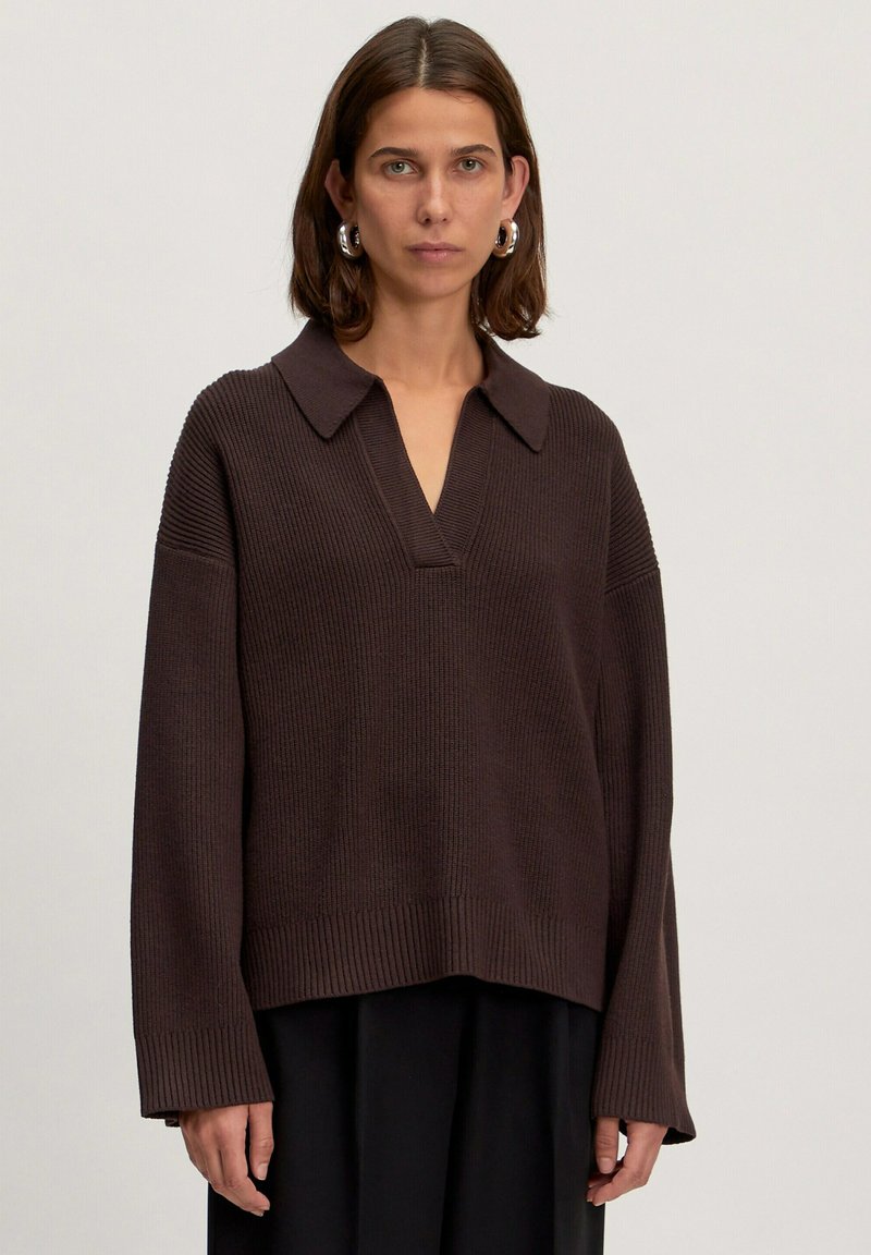 Bruin gebreid sweater met een colbertrand in V-vorm, verlaagde schouders en ribgebreide boorden en onderrand. Zachte textuur en een ontspannen pasvorm.