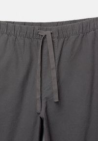 Pantalon gris foncé avec une taille élastique et un cordon assorti noué au centre devant.