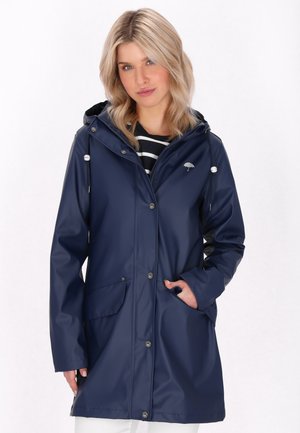 Chaqueta de lluvia impermeable en color azul marino con capucha, botones de presión, dos bolsillos frontales y un detalle de cordón. Textura suave y diseño casual.