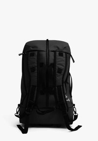 Mochila negra con correas de hombro acolchadas, cierre superior con cremallera y acentos de hardware en los laterales. Presenta un material texturado y duradero, con un diseño minimalista.
