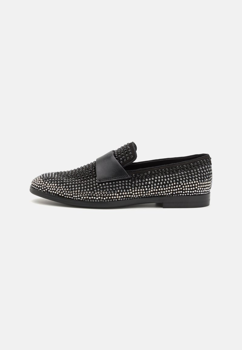 Black loafers with studded detailing, featuring a textured material, smooth leather accents, and a flat rubber sole.