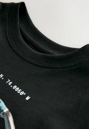 Sudadera de algodón negra con cuello acanalado y texto impreso en blanco. El diseño incluye coordenadas geográficas y un gráfico.