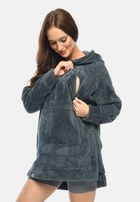 Flauschiger, dunkelgrauer Oversized-Hoodie mit einer Fronttasche und seitlichem Öffnung, ausgestattet mit einer Kapuze und einem weichen, strukturierten Stoff.