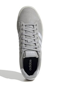 Baskets en daim grises avec des rayures blanches, tige texturée, bout rond, lacets plats et semelle intérieure noire avec le logo Adidas.