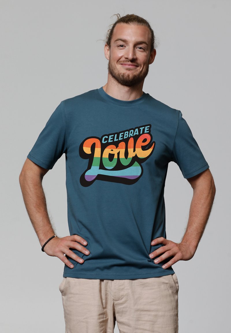 Cyan katoenen T-shirt met een kleurrafiek die "Celebrate Love" in oranje, geel, groen en blauwe tekst weergeeft. Korte mouwen, relaxte pasvorm.