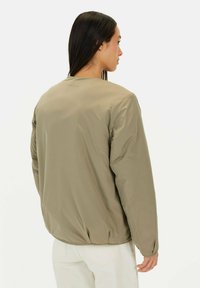 Steppjacke in gedämpftem Olivgrün mit glatter Textur und elastischem Saum. Verfügt über lange Ärmel und ein schlichtes, unaufdringliches Design.