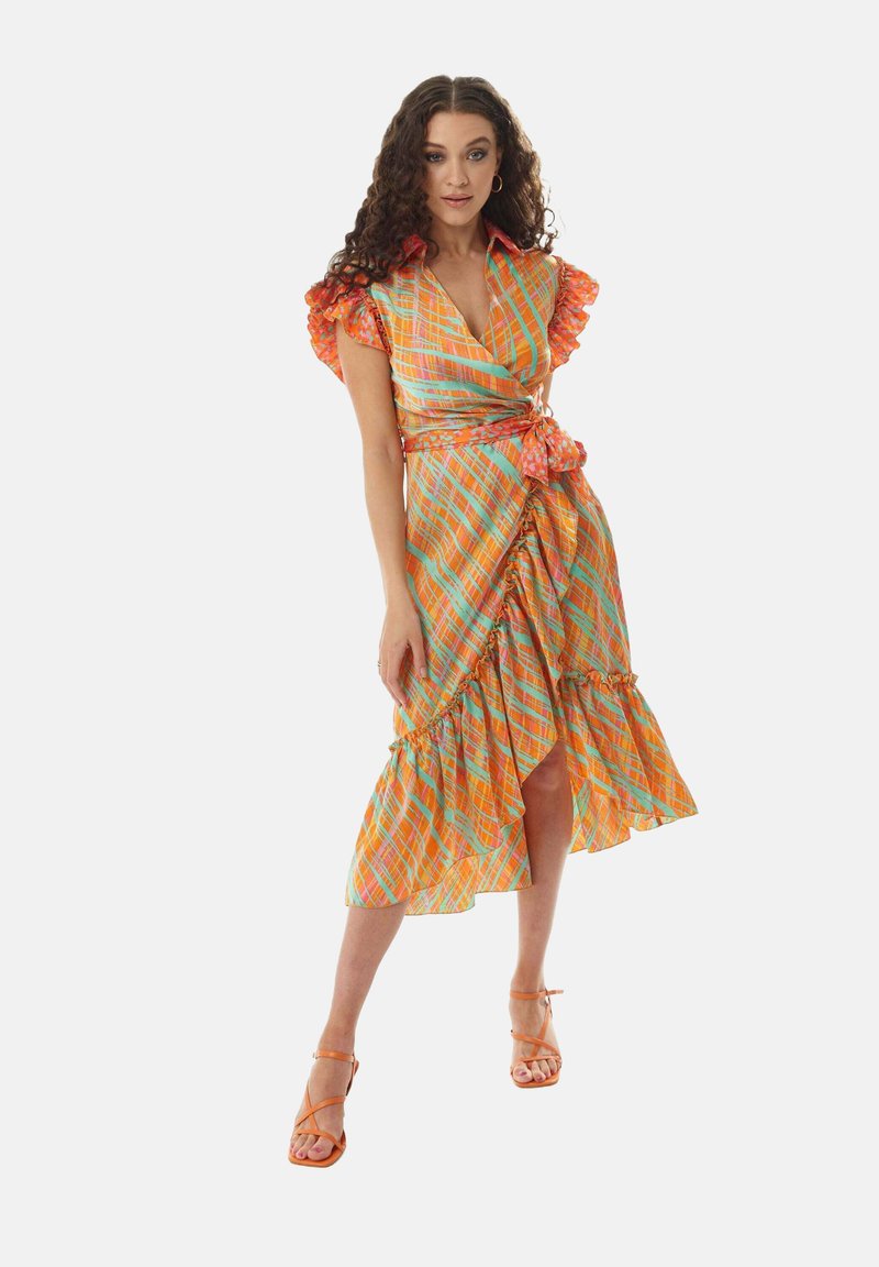 Colorful wrap dress in orange, green, and pink plaid pattern. Features ruffled sleeves, side tie, and a high-low hem with frills.