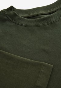 Olive green sweatshirt with a ribbed crew neck and cuffs. Features smooth texture and clean stitching in a minimalist design.