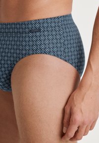 Herren-Schwimmbriefe mit einem geometrischen Diamantmuster in Dunkelblau und Hellblau, gefertigt aus einem weichen, elastischen Material für optimalen Tragekomfort.