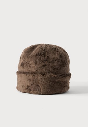 Pruuni karvane beanie-müts voltidega servaga, millel on esiküljel reljeefne The North Face'i logo, valgel taustal eksponeeritud.