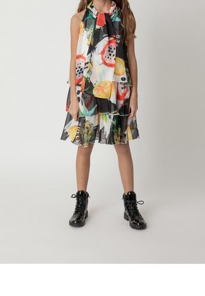 Kjolen har et flerfarvet frugtmønster, semitransparent stof, lagdelt design og et tørklædedetalje. Kombineret med sorte snørestøvler.