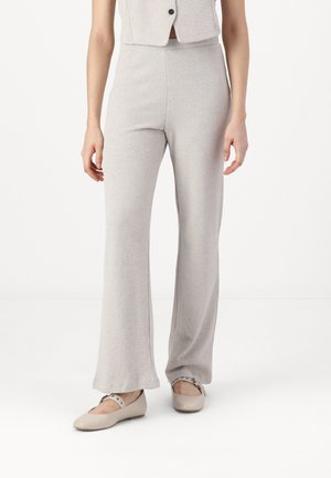 Light gray knit flared pants made from a textured fabric, featuring a fitted waist and straight legs, paired with beige flat shoes.