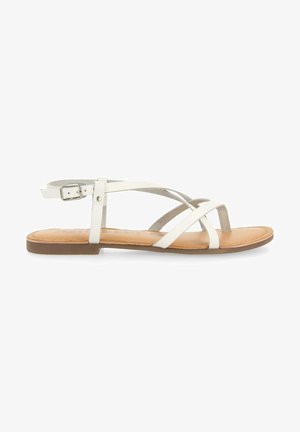 Witte sandalen met smalle bandjes, een vlakke tan-zool en een verstelbare enkelsluiting met gesp. Het bovendeel lijkt glad te zijn, met een suède accent.