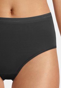 Schwarze Baumwollunterwäsche für Frauen mit glatter Textur, elastischem Bund und hohem Schnittdesign. Schlichte und nahtlose Konstruktion.