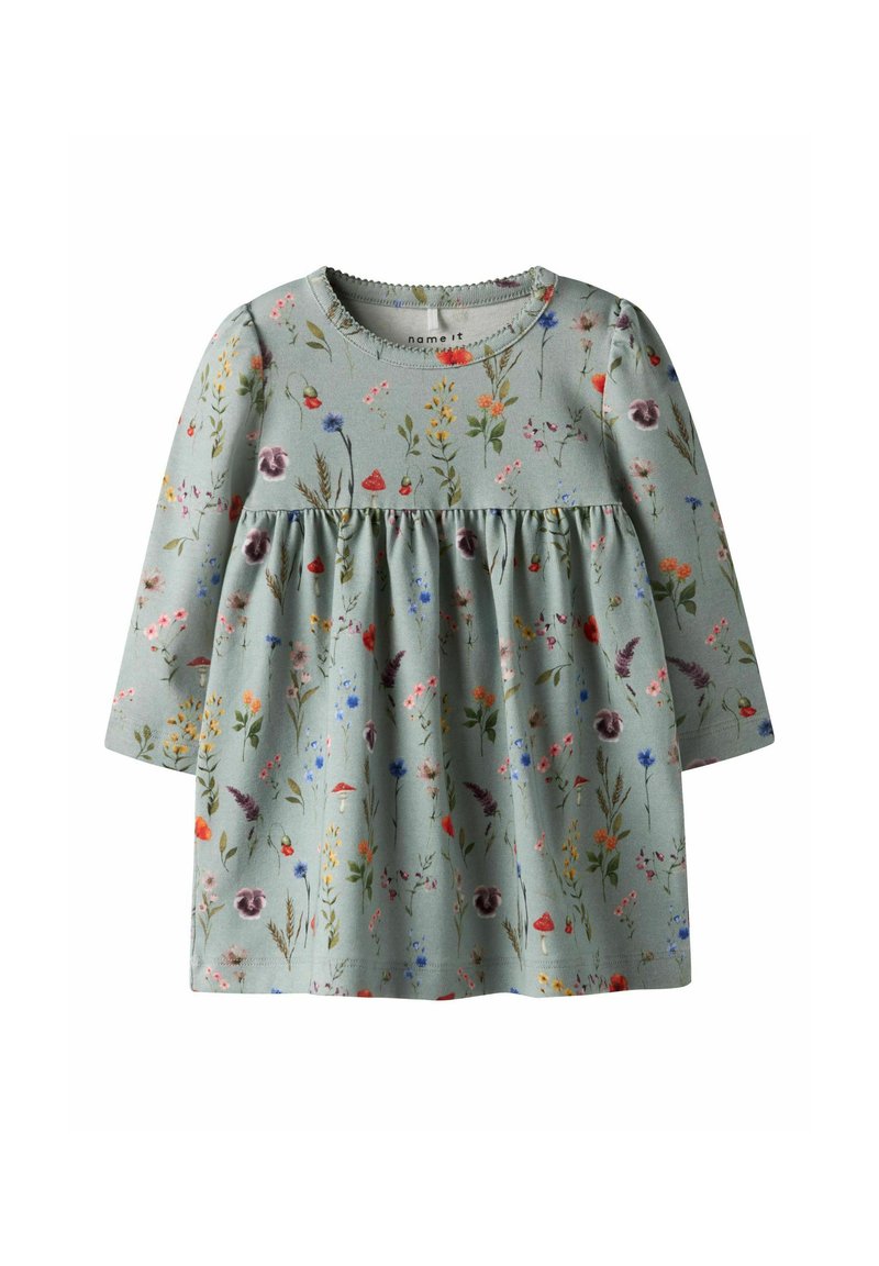 Robe verte à manches longues en tissu doux, ornée d'un motif floral avec diverses fleurs colorées, taille froncée et col rond.