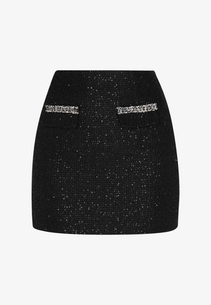 Jupe mini en tweed noir avec deux poches avant, rehaussée d'accents en métal argenté. Le tissu texturé a un éclat subtil.