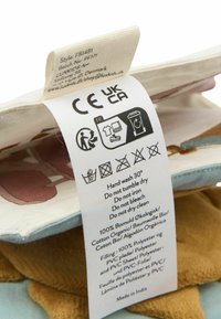 Étiquette d'entretien des vêtements indiquant les symboles de lavage, lavage à la main à 30°C, pas de séchage en machine, repassage, blanchiment ou nettoyage à sec, avec la composition du tissu et les détails d'origine.
