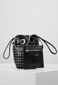 Svart läder bucketbag med silvernitar, snörad topp, kedjesnöre och en avtagbar zip-ficka med logodetalj.