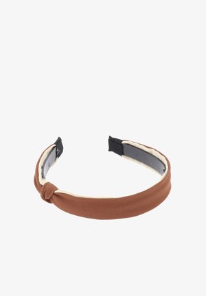 Diadema de tela marrón con un detalle de nudo en la parte delantera, con un forro interior suave y una base de plástico. Extremos de la correa en negro para ajustar.