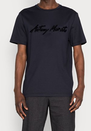 Camiseta de algodón navy con mangas cortas, cuello redondo y letras en relieve de color negro "Antony Morato" en el pecho. Textura suave y corte regular.