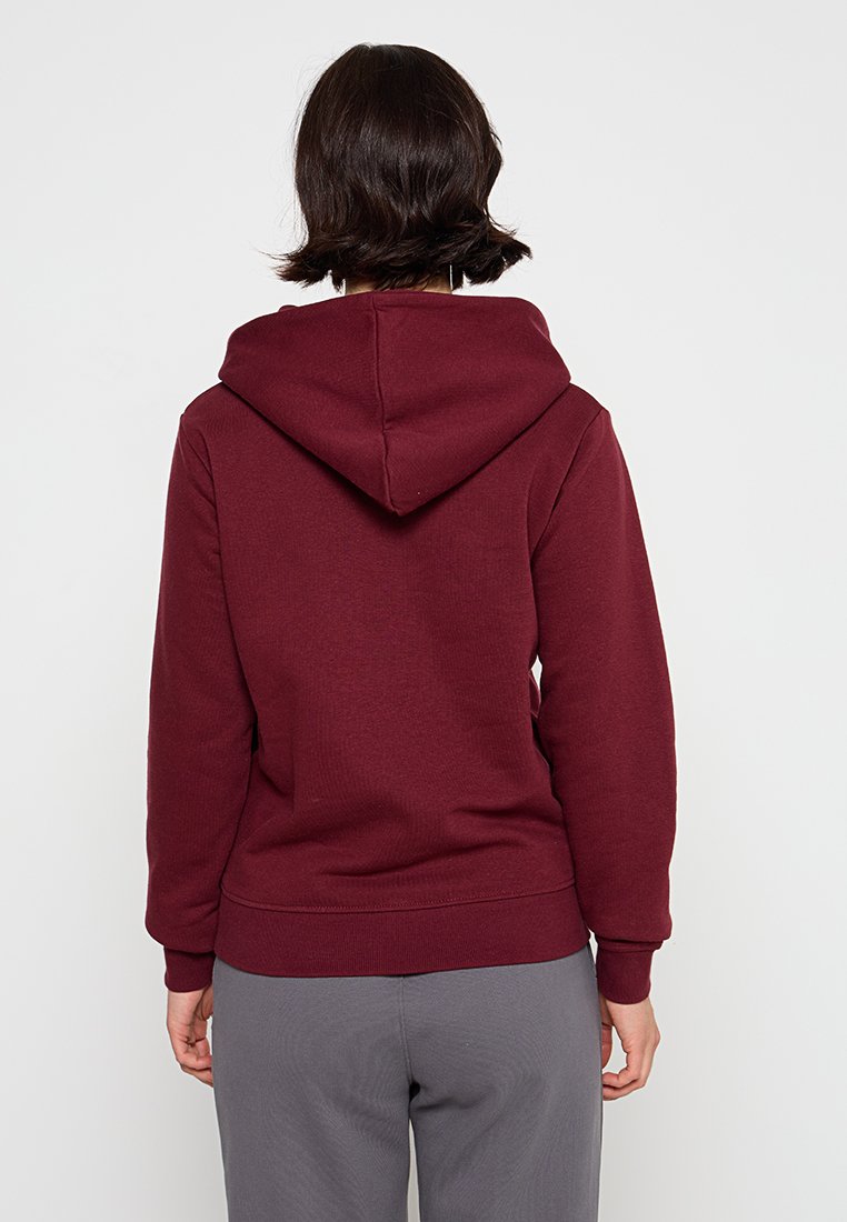 Bordeauxfarbener Pulli mit Kapuze, gefüttert, mit gerippten Bündchen und Saum. Aus weichem Stoff gefertigt, mit glatter Textur und lässiger Passform.