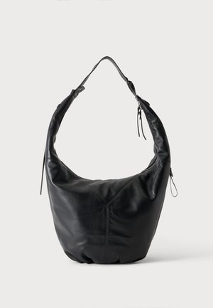 Borsa a tracolla in morbida pelle nera con tracolla larga e chiusura con cerniera, mostrata su uno sfondo chiaro uniforme.