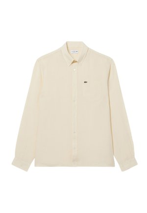 Camicia beige a maniche lunghe con bottoni, taschino sul petto e piccolo logo del coccodrillo verde sul lato sinistro.